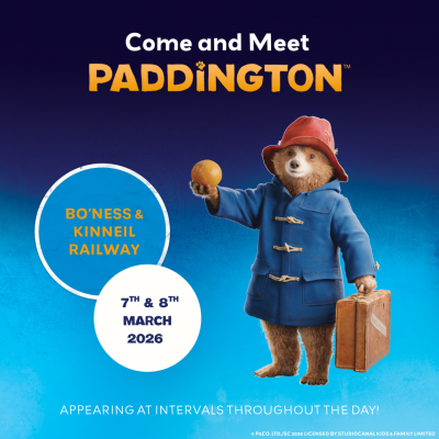 Paddington holding a fruit promoting journeys in Scotland